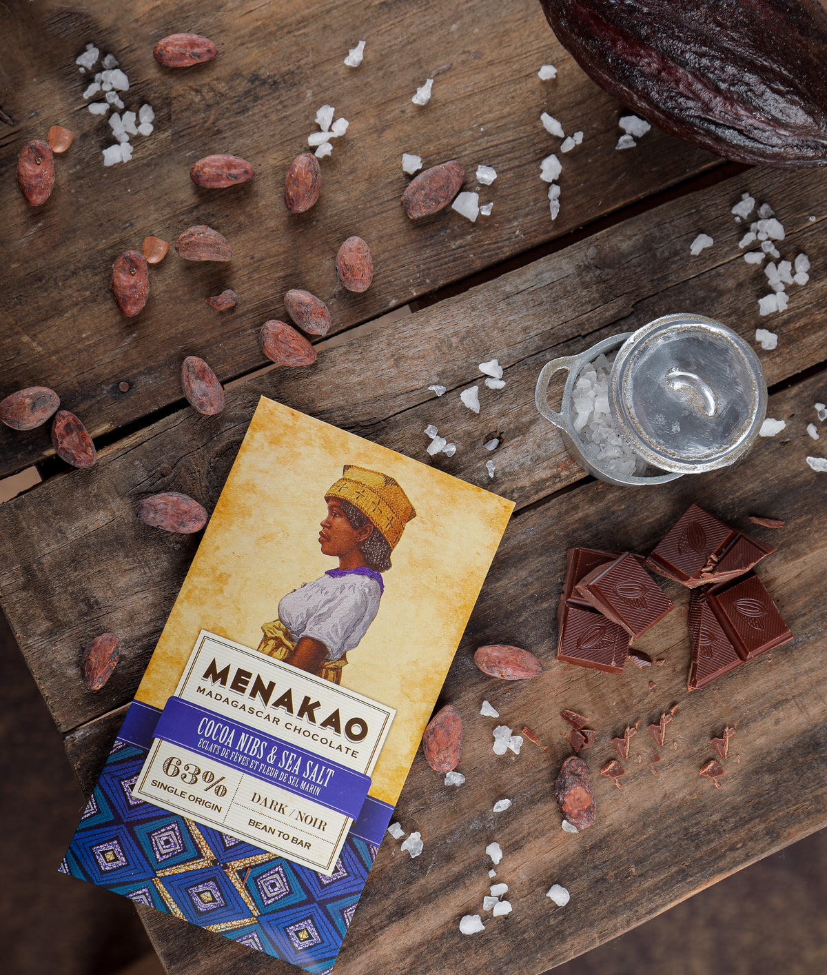 63% dark chocolate bar with cocoa nibs and sea salt on wooden surface