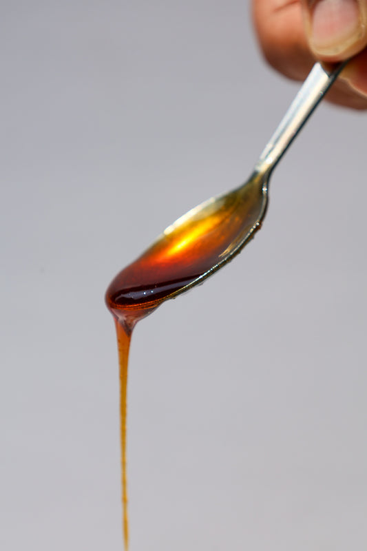 Mangrove honey dripping from a spoon