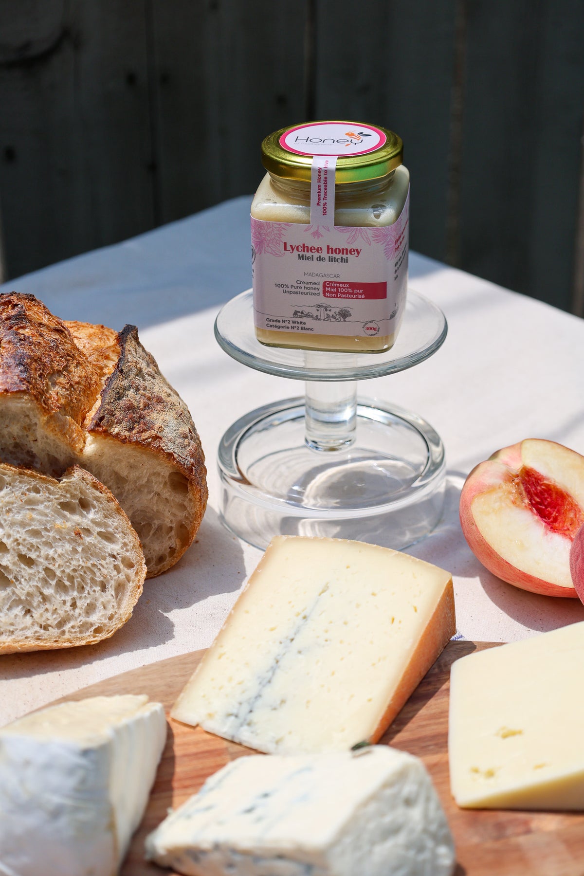 Lychee honey jar on a cheese board with assorted cheeses