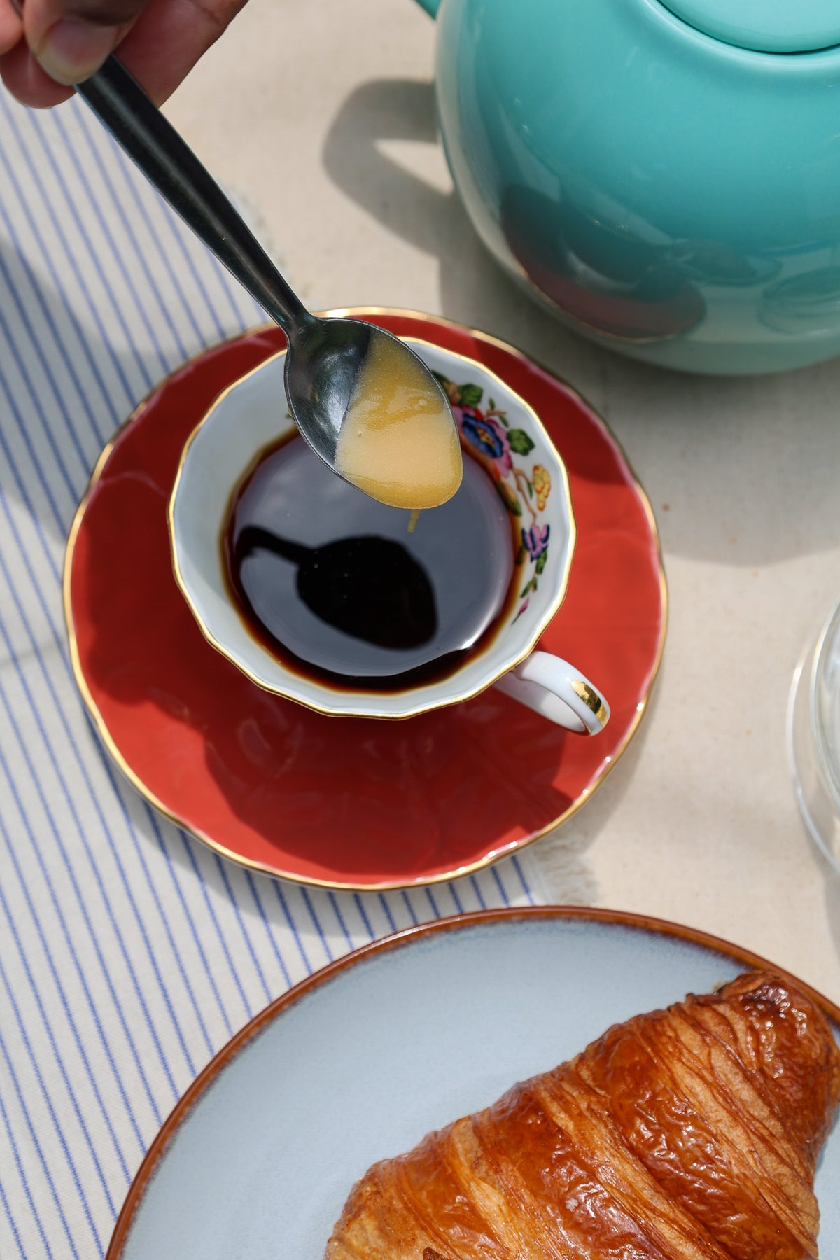 Niaouli honey stirred into a cup of tea on a wooden table