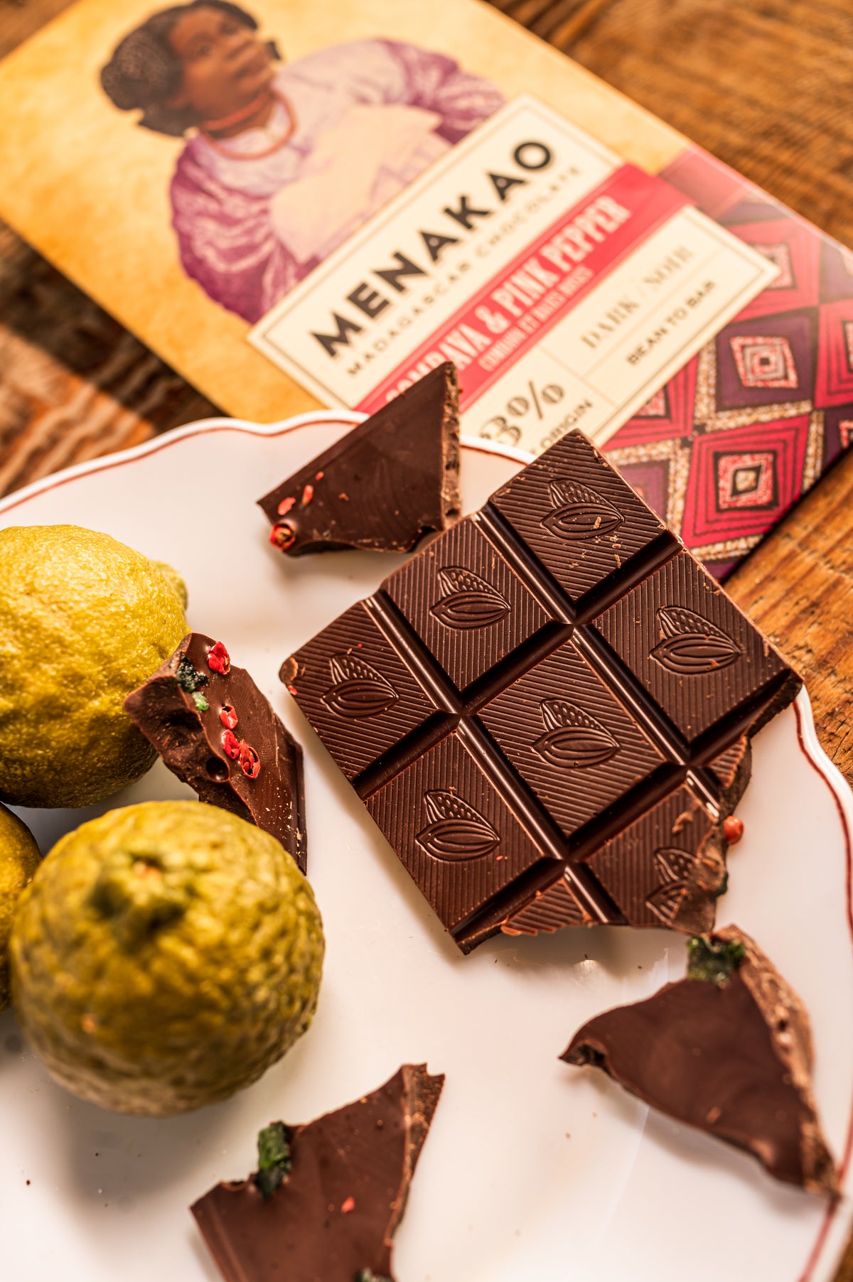 Close-up of 63% dark chocolate bar with combava and pink berries