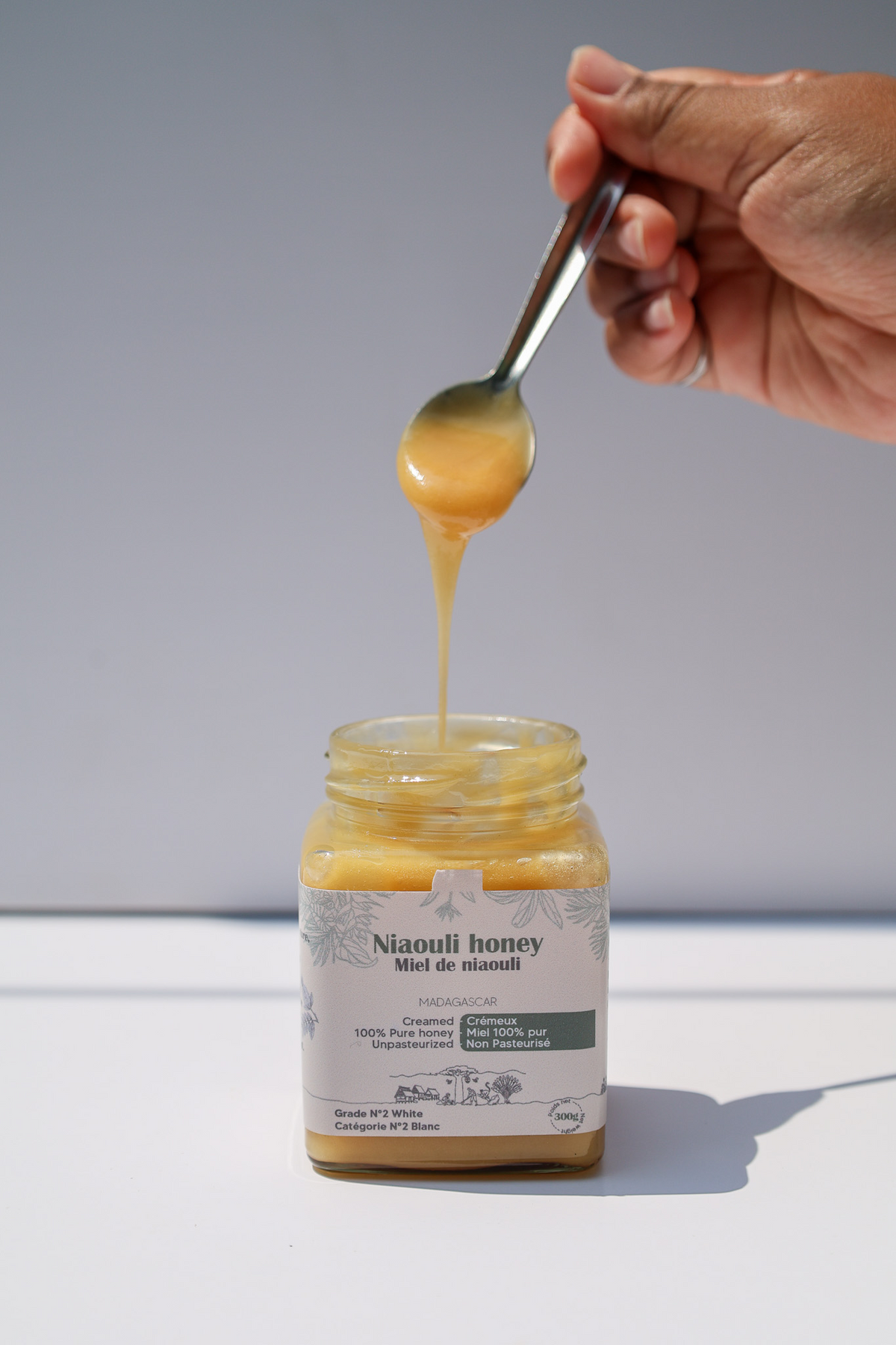 Niaouli honey dripping from a spoon into a jar